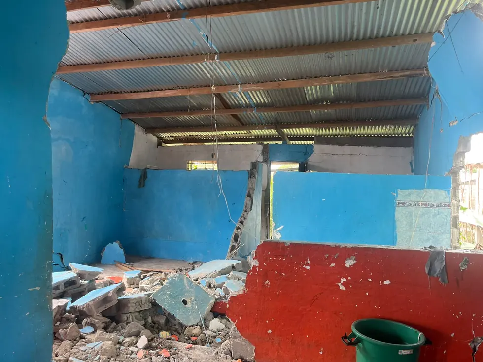 Interior de una vivienda del Chocó con las paredes derrumbadas sobre el piso