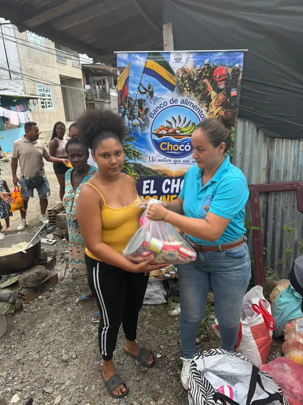 Voluntaria del Banco de Alimentos del Chocó entregando un mercado en mano a una vecina
