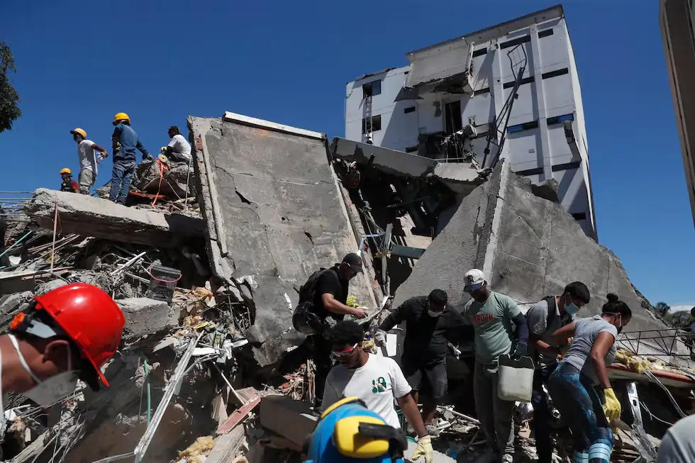 Equipos de rescate trabajando sobre un edificio colapsado