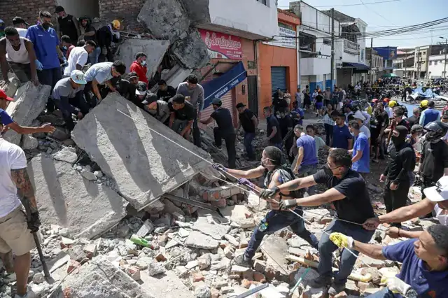 Vecinos formando una cadena humana para remover una losa de concreto