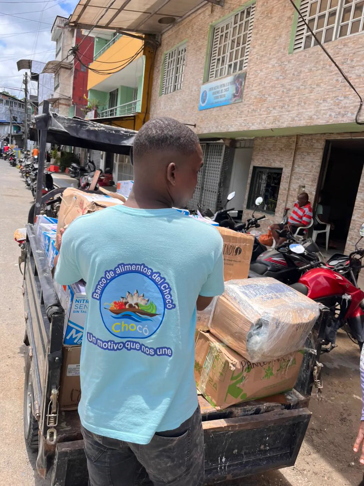 Voluntario del Banco de Alimentos del Chocó cargando donaciones en un motocarro en Quibdó