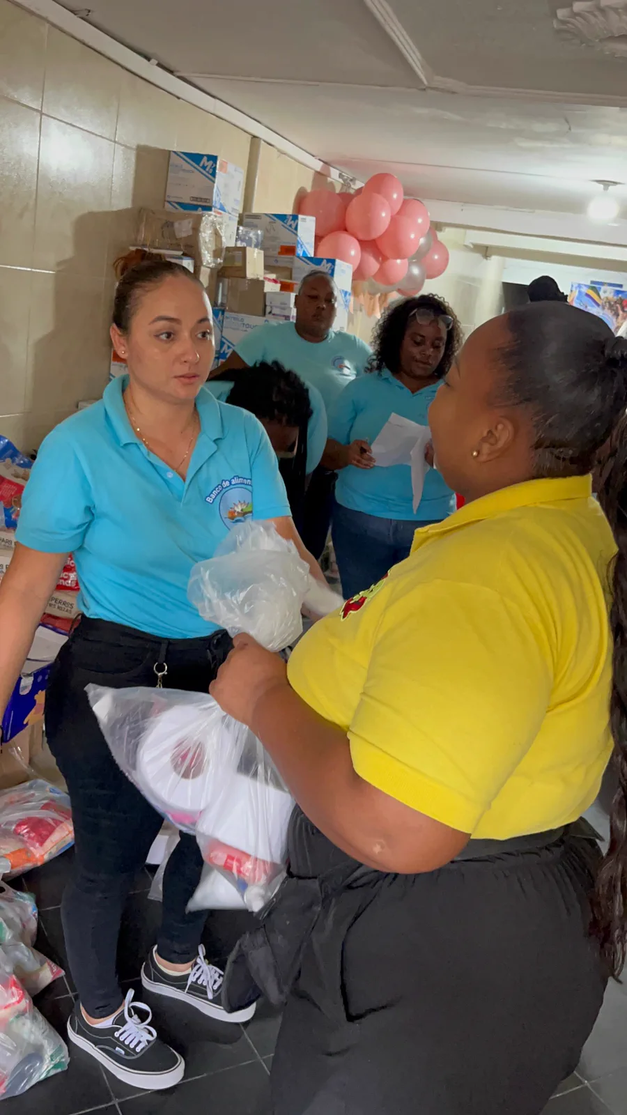 Voluntaria entregando un mercado en mano a una vecina del barrio en Quibdó